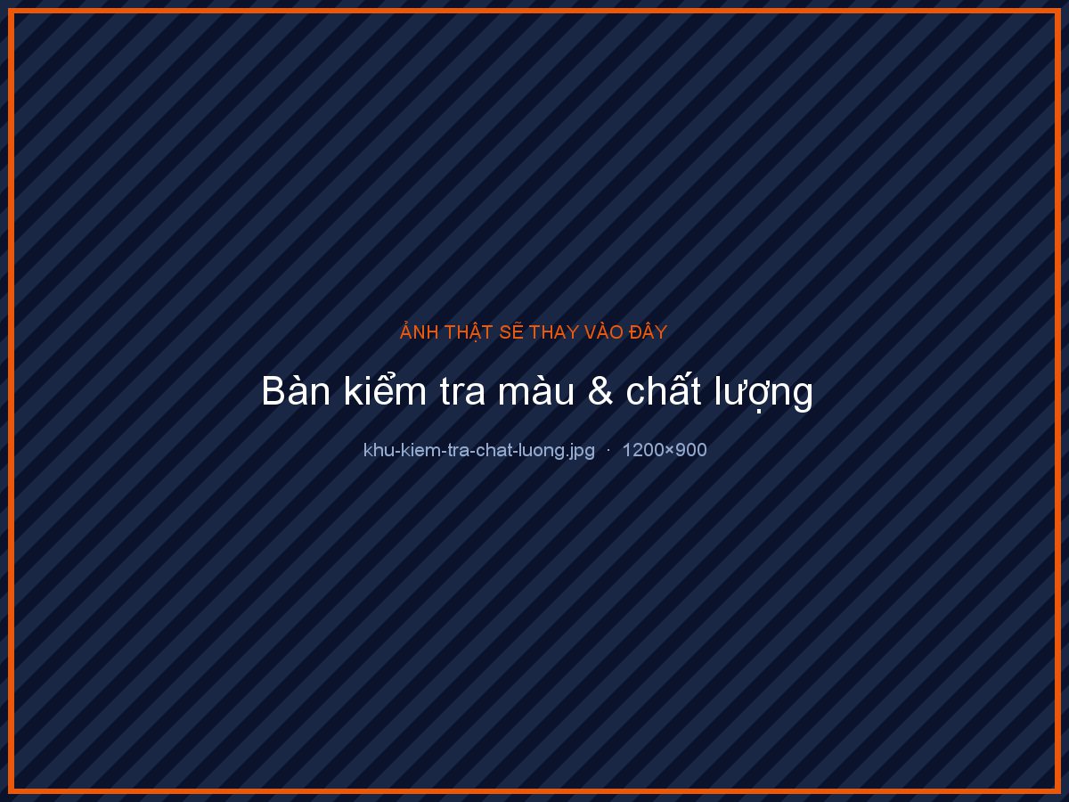 Ảnh chụp bàn kiểm tra chất lượng trong xưởng in, mặt bàn trắng dưới đèn soi màu chuẩn, người thợ dùng kính lúp soi một tờ in màu vừa ra máy, bảng màu CMYK và thước canh tràn lề đặt bên cạnh, vài tờ in mẫu xếp thành hàng để so sánh, chụp cận trung từ trên xuống chéo, ảnh thương mại chân thực, tỉ lệ 4:3
