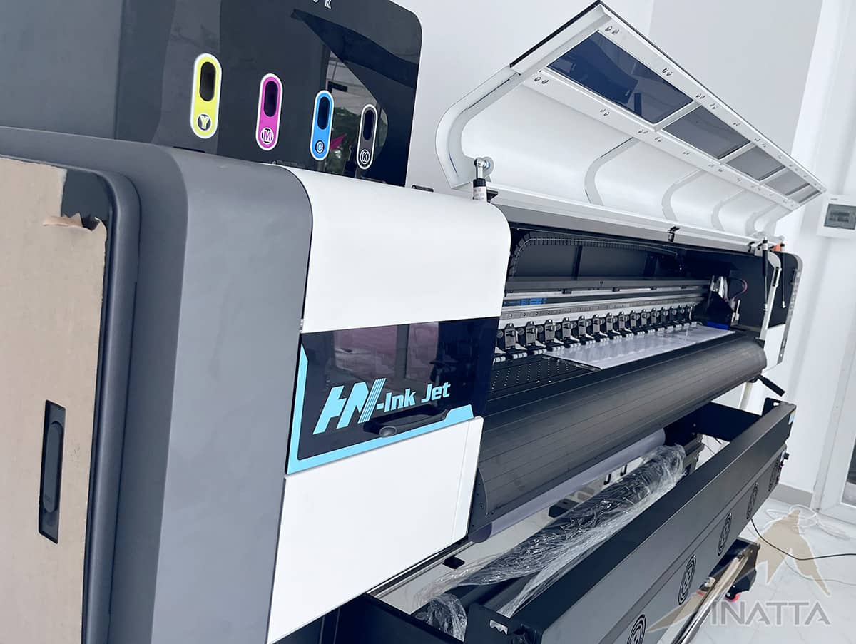 Máy in phun khổ lớn HN-Ink Jet tại xưởng INATTA, nắp máy mở để lộ dàn đầu phun và trục cuốn vật liệu